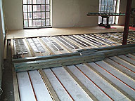 janssen-fussbodenheizung im trockenaufbau - heizrohre mit aufgesteckten aluminium-waermeverteilern zwischen den bodenlagern